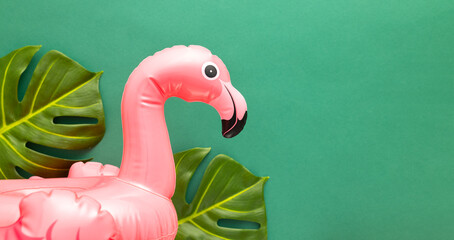 Summer beach party concept. Pink flamingo, tropical leaf monstera and orchid flowers on green...