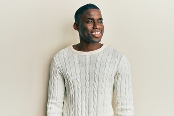 Young african american man wearing casual clothes looking away to side with smile on face, natural expression. laughing confident.