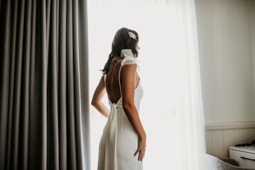 Fototapeta na wymiar bride zipping buttoning her white wedding dress 