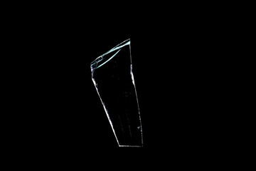 glass fragments in isolation on a black background. damaged window. damaged object