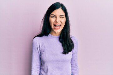 Young hispanic woman wearing casual clothes winking looking at the camera with sexy expression,...