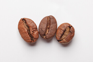 three coffee beans isolated on white background, macro photo