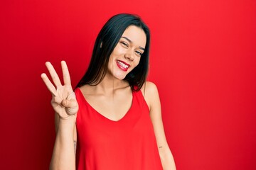 Young hispanic girl wearing casual style with sleeveless shirt showing and pointing up with fingers number three while smiling confident and happy.