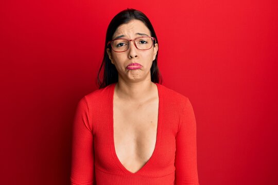 Young latin woman wearing casual clothes and glasses depressed and worry for distress, crying angry and afraid. sad expression.