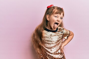 Little caucasian girl kid wearing festive sequins dress winking looking at the camera with sexy expression, cheerful and happy face.