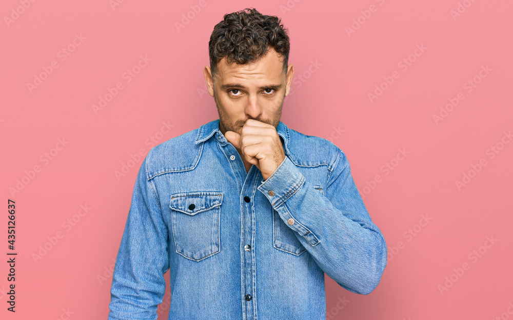 Sticker young hispanic man wearing casual denim jacket feeling unwell and coughing as symptom for cold or br