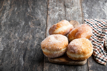 Traditional homemade doughnut with jam filling on wooden table
