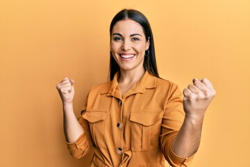 Young brunette woman wearing casual clothes screaming proud, celebrating victory and success very excited with raised arms