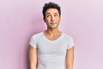 Young handsome man wearing casual white t shirt smiling looking to the side and staring away thinking.