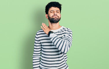 Fototapeta premium Young arab man with beard wearing casual striped sweater cutting throat with hand as knife, threaten aggression with furious violence