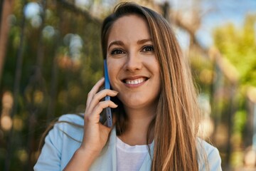 Young blonde businesswoman smiling happy talking on the smartphone at the city.