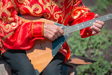 A man plays the balalaika. Russian folk musical instrument.
