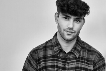 Young hispanic man posing with relaxed expression looking to the camera.