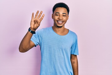 Young african american man wearing casual blue t shirt showing and pointing up with fingers number four while smiling confident and happy.