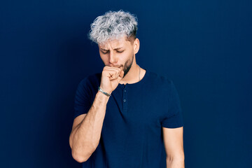 Young hispanic man with modern dyed hair wearing casual blue t shirt feeling unwell and coughing as symptom for cold or bronchitis. health care concept.