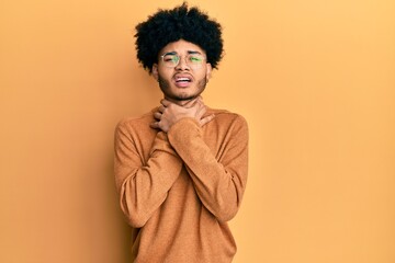 Fototapeta na wymiar Young african american man with afro hair wearing casual winter sweater shouting and suffocate because painful strangle. health problem. asphyxiate and suicide concept.
