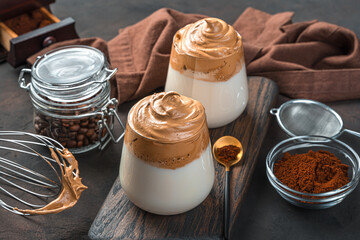 Two glasses of dalgona coffee on a brown background. A traditional Korean drink.