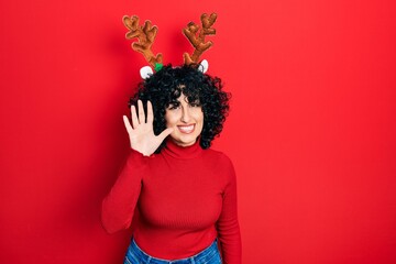 Young middle east woman wearing cute christmas reindeer horns showing and pointing up with fingers number five while smiling confident and happy.