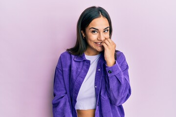 Young brunette woman wearing casual clothes looking stressed and nervous with hands on mouth biting...