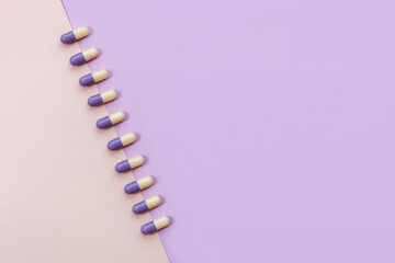 Multi-colored pills on pastel background. Taking dietary supplements. Life before and after...