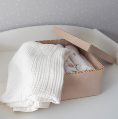 Baby's diapers and blanket in a gift box on white background. Expectation and preparation of childbirth surprise gift for newborn. 