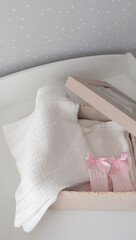 Vertical of baby's clothes and socks in a gift box on white background. Expectation and preparation of childbirth surprise gift. 