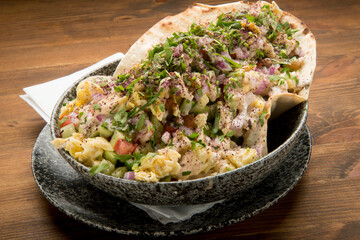 Tomatos, cucumbers, red onion and parsley, finely chopped, seasoned with olive oil and lemon,topped by scrambled eggs, Tahini and Sumak.