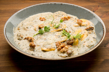 Baked potato with a mushroom cream sauce, mozzarella, and fresh basil leaves.