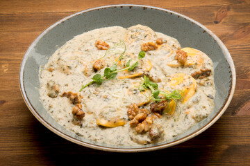 Baked potato with a mushroom cream sauce, mozzarella and fresh basil leaves.