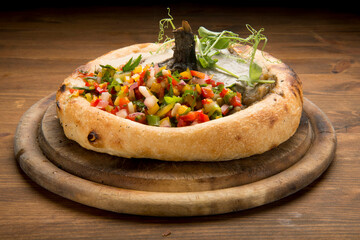 Grilled eggplant with konkassa, black and white Tahini, and pine nuts, served in sambusakpastry