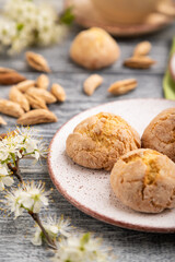 Almond cookies and a cup of coffee on a gray wooden background. Side view, selective focus.