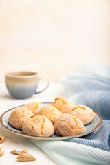 Almond cookies and a cup of coffee on a white concrete background Side view, selective focus, copy space.