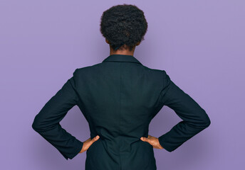 Young african american girl wearing business clothes standing backwards looking away with arms on body - Powered by Adobe