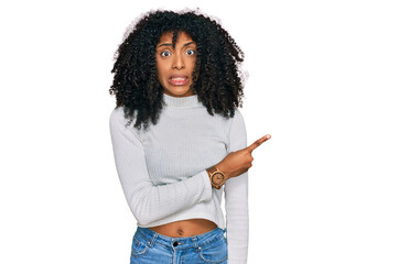 Young african american girl wearing casual clothes pointing aside worried and nervous with...