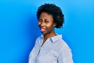 Young african american woman wearing casual clothes winking looking at the camera with sexy...