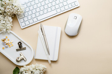 Neutral color tabletop with pc keyboard, notepad and white flowers, home office objects