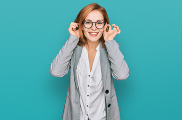 Young caucasian woman wearing business style and glasses smiling pulling ears with fingers, funny...