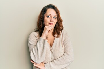 Young caucasian woman wearing casual clothes with hand on chin thinking about question, pensive expression. smiling with thoughtful face. doubt concept.