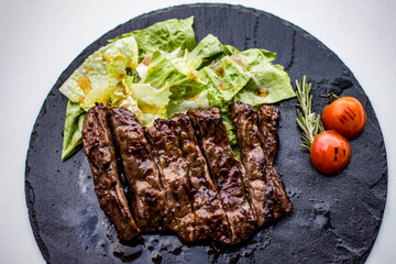 Grilled meat and vegetables. Sweet and sour honey sauce. Stone tray