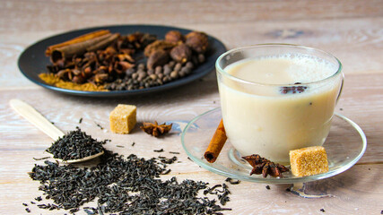 Traditional indian drink - masala tea with spices wooden background. Close up popular Indian or...