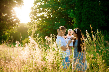 Happy family in the park evening light. The lights of a sun.