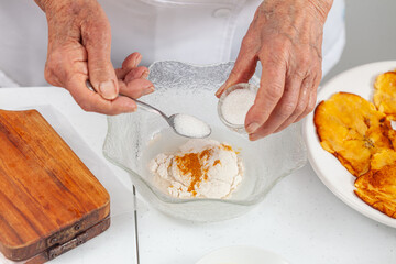 Senior woman preparing a traditional dish from el Valle del Cauca in Colombia called aborrajado
