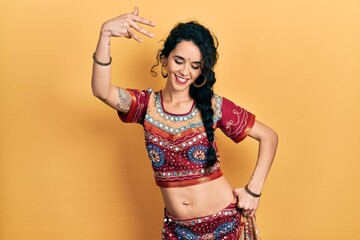 Young indian woman wearing traditional belly dancer costume. Dancing exotic oriental dance with body and hands