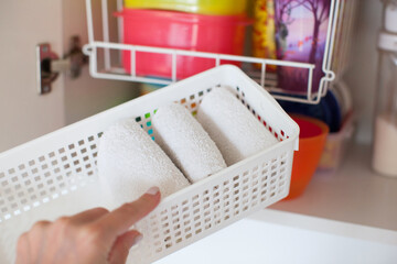 Storage in the kitchen. Towel organization in white basket. 