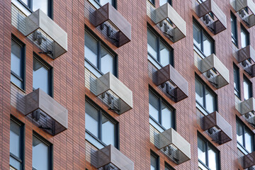 The facade of a new high-rise building with windows and compartments for external blocks of split...
