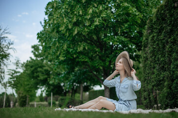 Fototapeta premium Romantic girl with hat on picnic in park