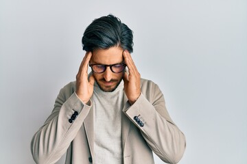 Young hispanic man wearing business jacket and glasses with hand on head for pain in head because stress. suffering migraine.