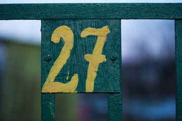 Tabliczka na ogrodzeniu z numerem 27