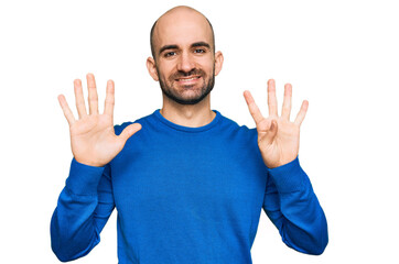 Naklejka premium Young hispanic man wearing casual clothes showing and pointing up with fingers number nine while smiling confident and happy.