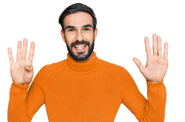 Young hispanic man wearing casual clothes showing and pointing up with fingers number nine while...